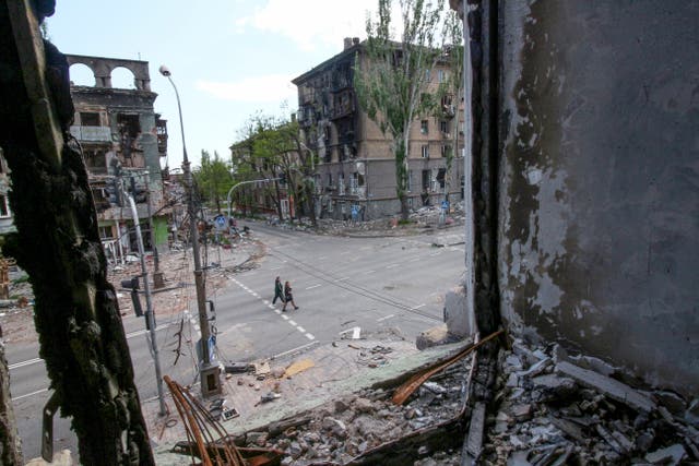 People walk among buildings destroyed during fighting in Mariupol, in territory under the government of the Donetsk People’s Republic, eastern Ukraine, Wednesday, May 25, 2022. (AP Photo)