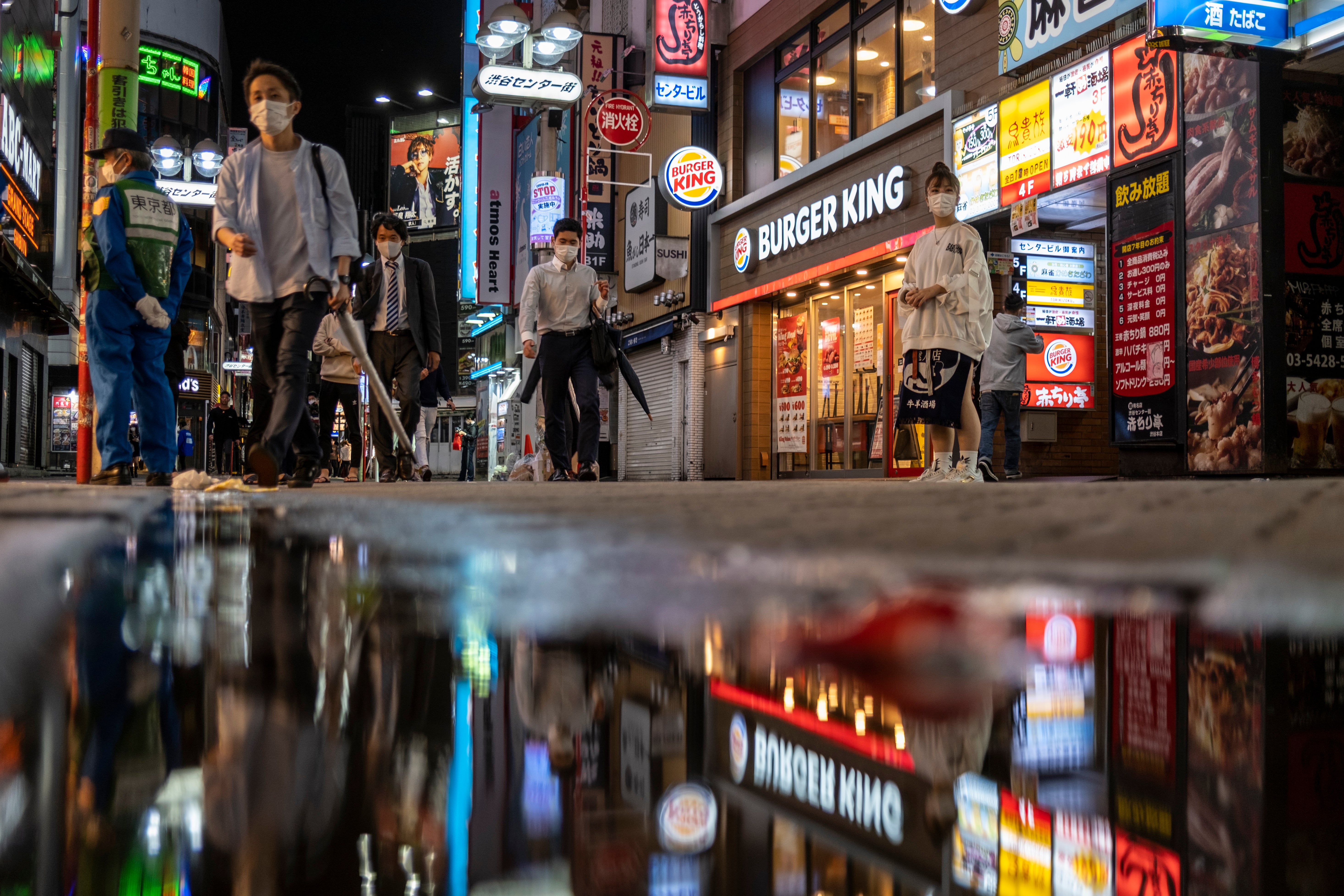 People walk along the streets full of bars and restaurants in Shibuya, an entertainment district of Tokyo (stock image)