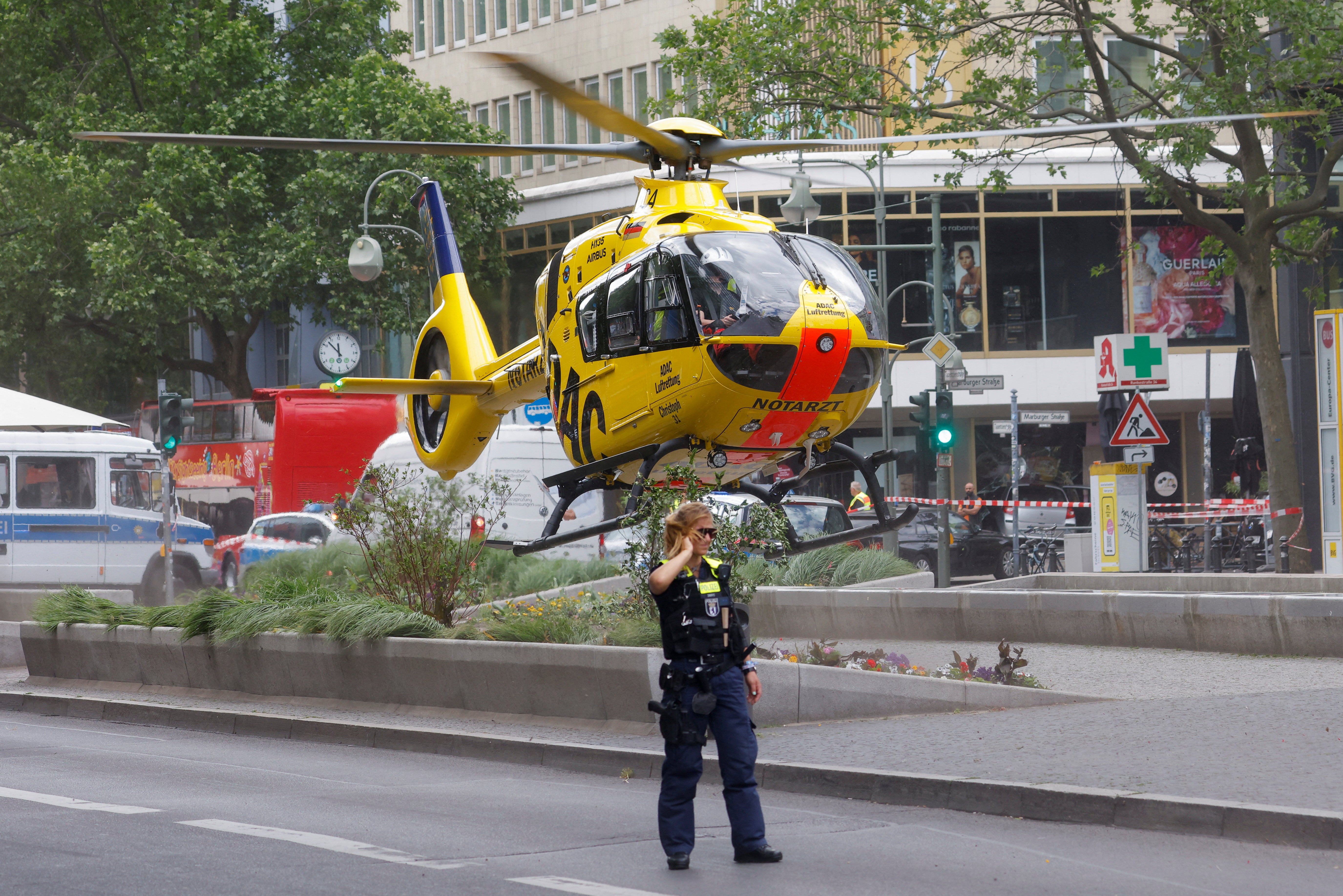 A police officer walks as a first-response helicopter takes off at the scene where a car crashed into a group of people near Breitscheidplatz in Berlin