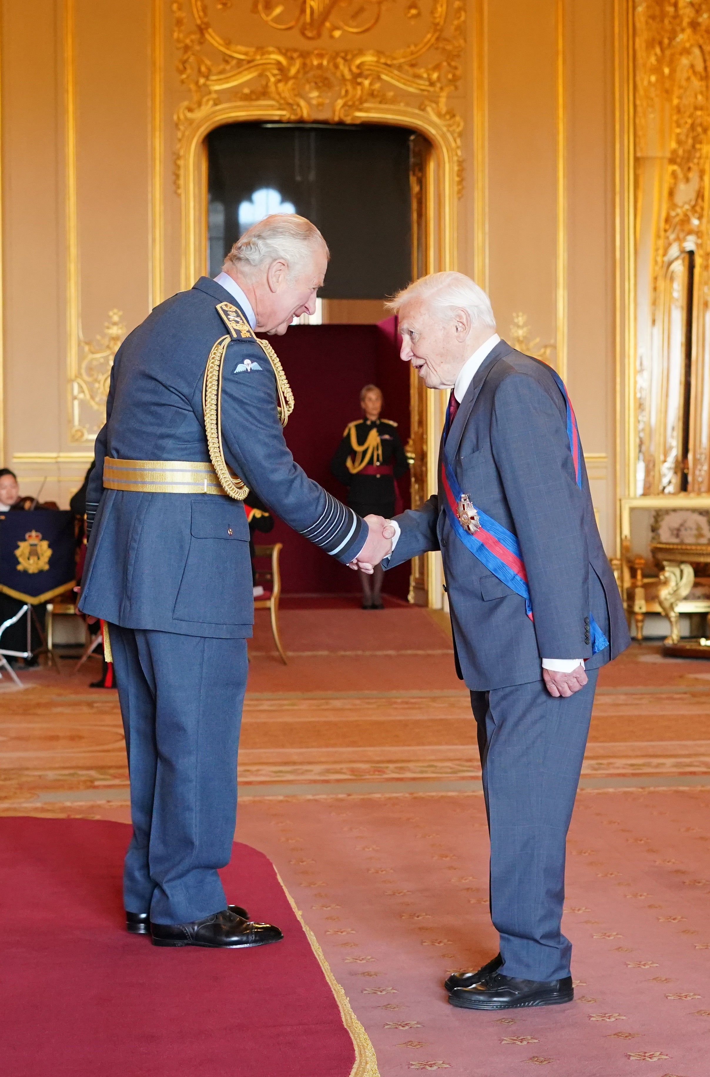 The broadcaster collects his honour from Prince Charles at an investiture ceremony at Windsor Castle on Wednesday