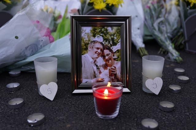 A lit candle and picture frame next to floral tributes left near the scene at Dragon Rise in Norton Fitzwarren, near Taunton in Somerset, where Stephen and Jennifer Chapple died (Andrew Matthews/PA)