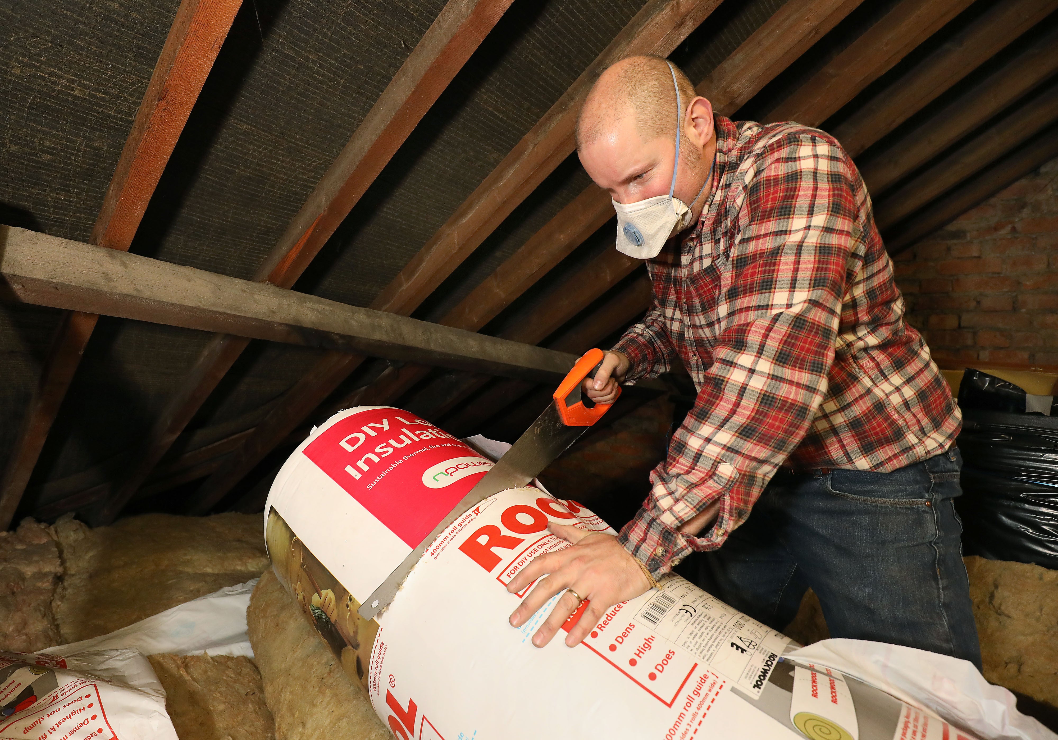 A man laying loft insulation