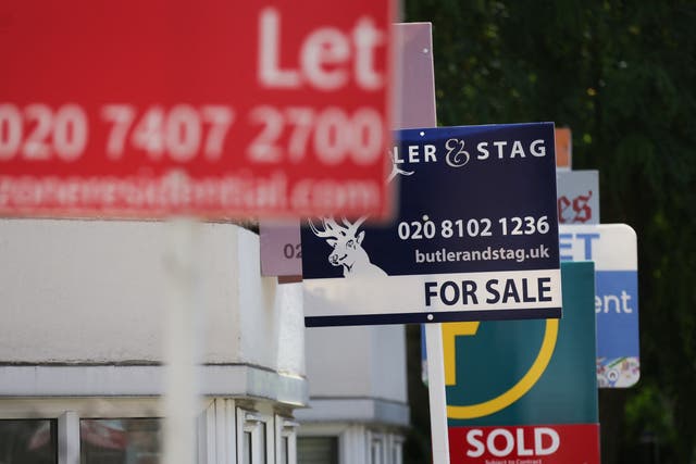 <p>Estate agents placards are seen in front of houses in London</p>