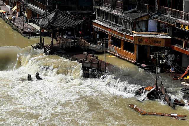 <p>Flood waters sweep through the ancient town of Feng Huang in central China’s Hunan province, Saturday, 4 June 2022 </p>