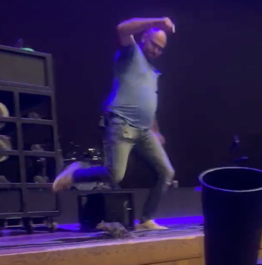 A man attempts to kick a rodent off the stage at the Halsey concert in Maryland on Wednesday