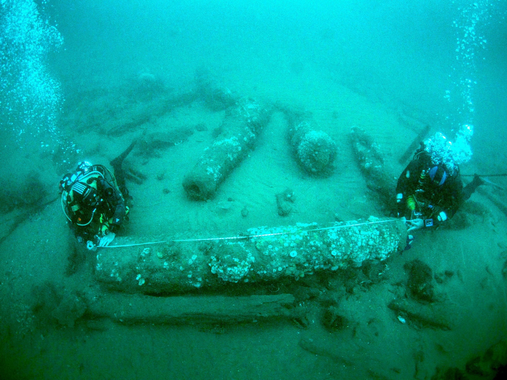 Brothers Julian and Lincoln Barnwell measuring a cannon that was found with the wreck