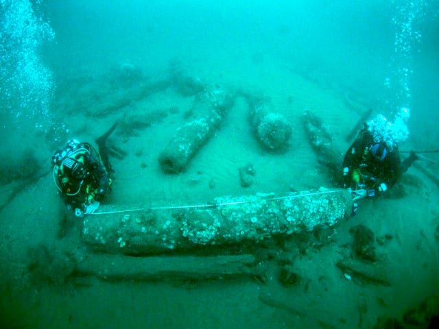 <p>Brothers Julian and Lincoln Barnwell measuring a cannon that was found with the wreck</p>