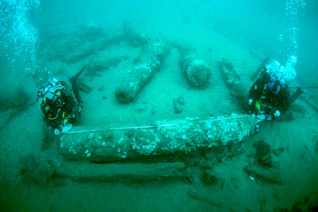 <p>Brothers Julian and Lincoln Barnwell measuring a cannon that was found with the wreck</p>