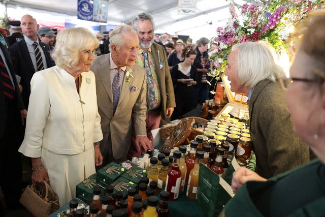 The Duchess of Cornwall and the Prince of Wales speak to exhibitors at the Royal Cornwall Show (PA)
