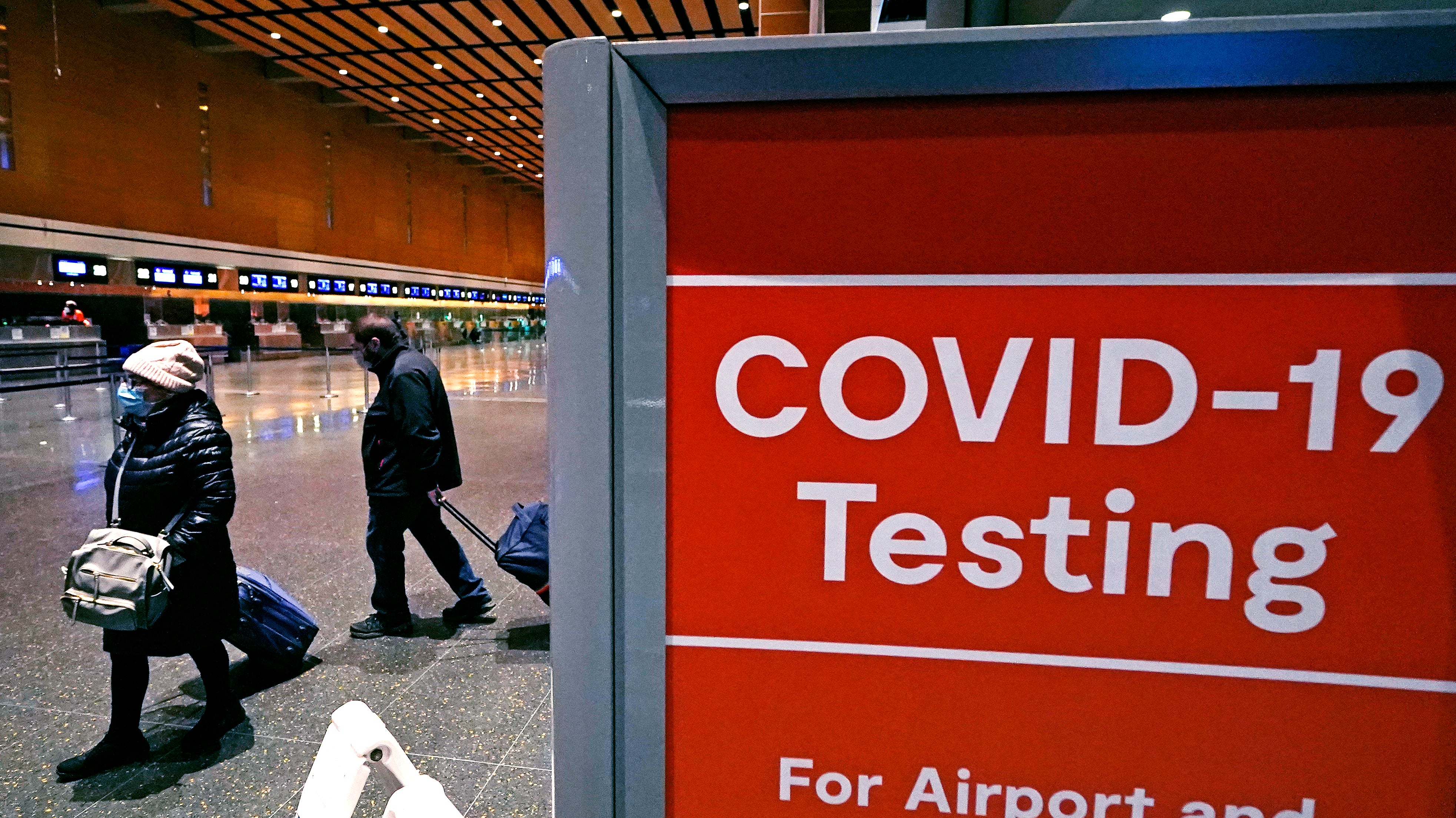 Passengers pass a COVID-19 testing site at Boston airport