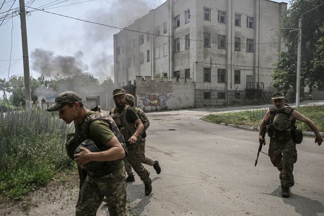 <p>Ukrainian servicemen run for cover in the city of Lysychansk, in the Donbas region of eastern Ukraine</p>