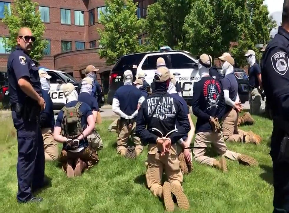 <p>Police officers guard a group of men, who police say are among 31 arrested for conspiracy to riot and are affiliated with white nationalist group Patriot Front, after they were found in the rear of a U Haul van in the vicinity of a North Idaho Pride Alliance LGBT+ event in Coeur d’Alene, Idaho</p>