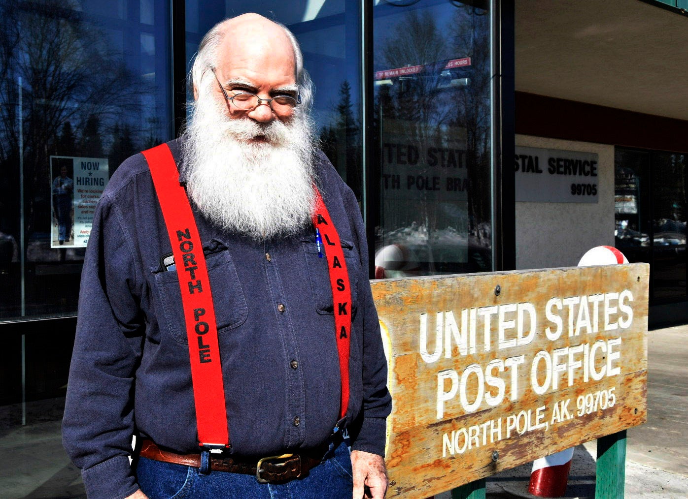 Santa Claus stands in front of the North Pole post office
