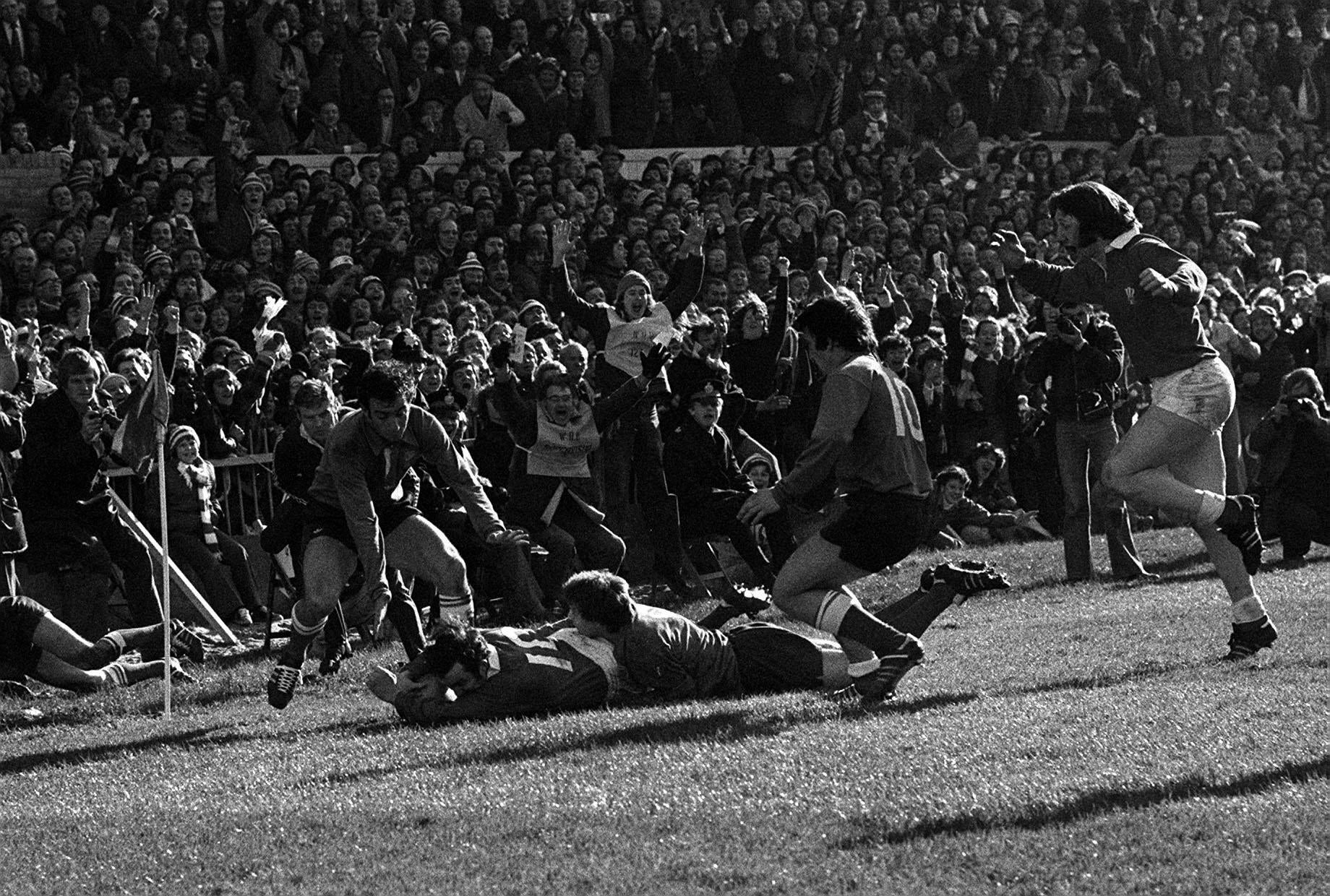 Phil Bennett (right, on the ground) scores a try for Wales against France in the Five Nations (PA).