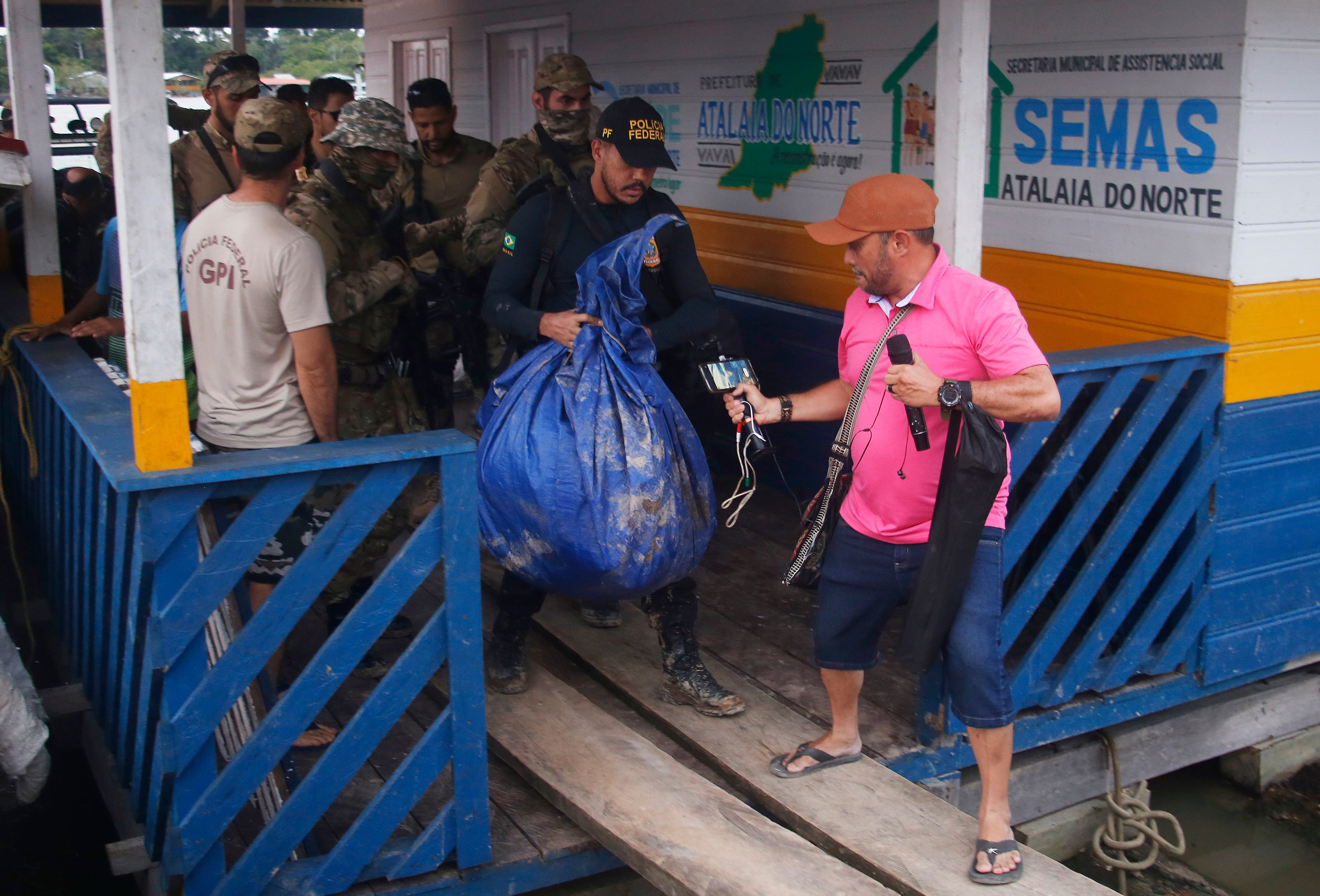 A police officer carries a bag containing items recovered by a search party near Atalaia do Norte