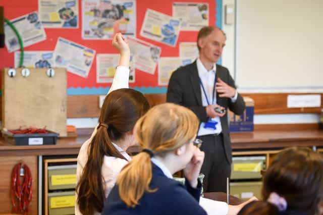A teacher talks with students in a science class at Royal High School Bath. (Ben Birchall/PA)