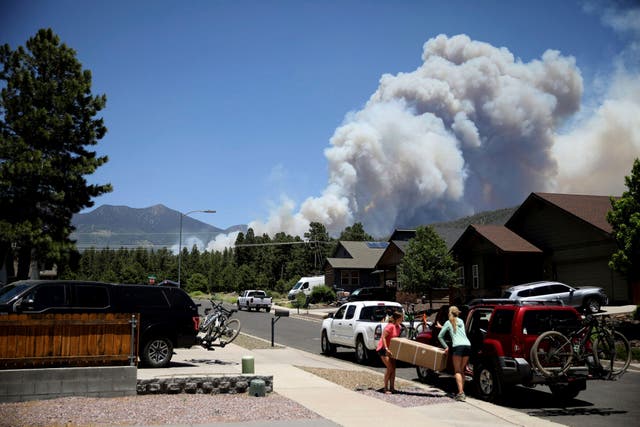 <p>People evacuate their home as the Pipeline Fire burns in the mountains above Flagstaff, Arizona on 12 June 2022</p>