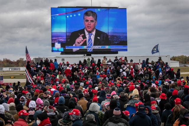 <p>File: Supporters of Donald Trump watch a video featuring Fox host Sean Hannity ahead of Trump’s arrival to a campaign rally at Oakland County International Airport on 30 October 2020</p>