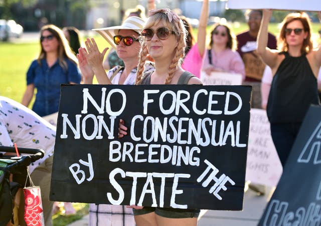 <p>Activist holds a protest sign during a  rally in front of the Duval County Courthouse on 4 May</p>