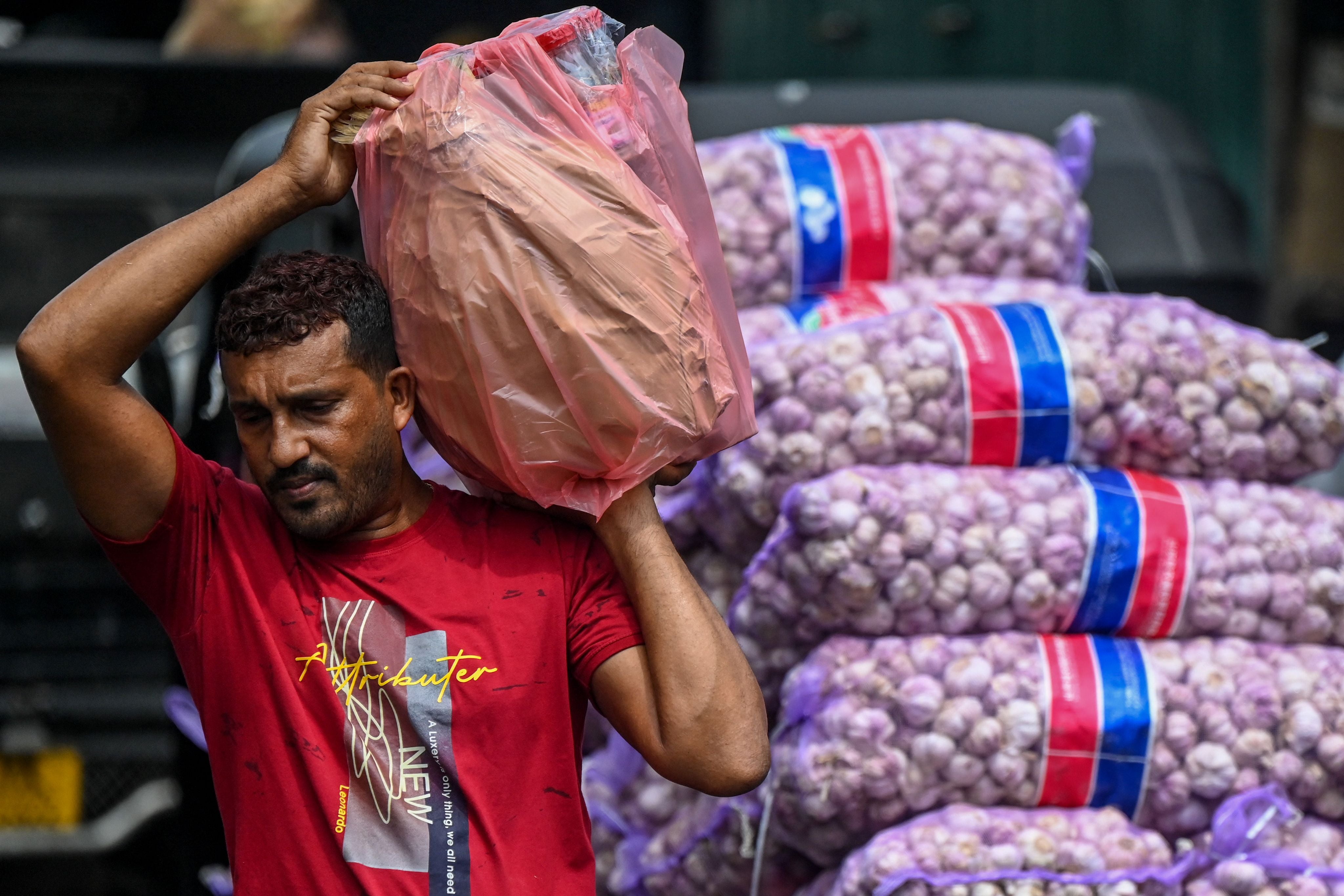 Workers transport essential goods at a market in Colombo last month