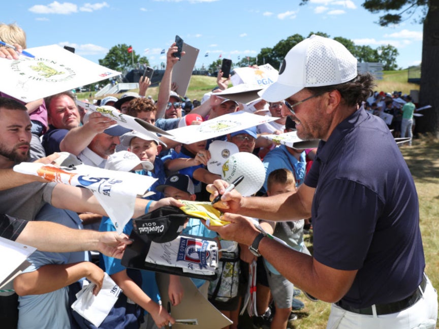 Phil Mickelson signs autographs during a practice round at the US Open