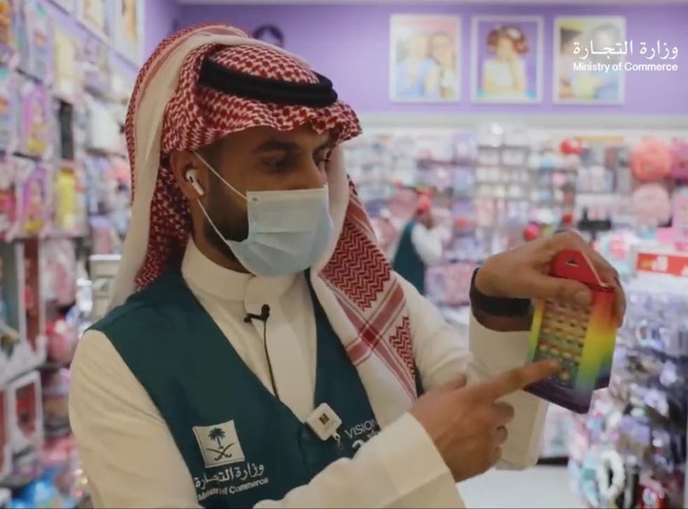 <p>A Saudi official points out the rainbow colours on what appears to be a pack of false nails</p>