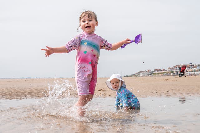 <p>Esmae Crawforth, left, and Ione Crawforth enjoy the hot weather on Bridlington beach on Thursday</p>