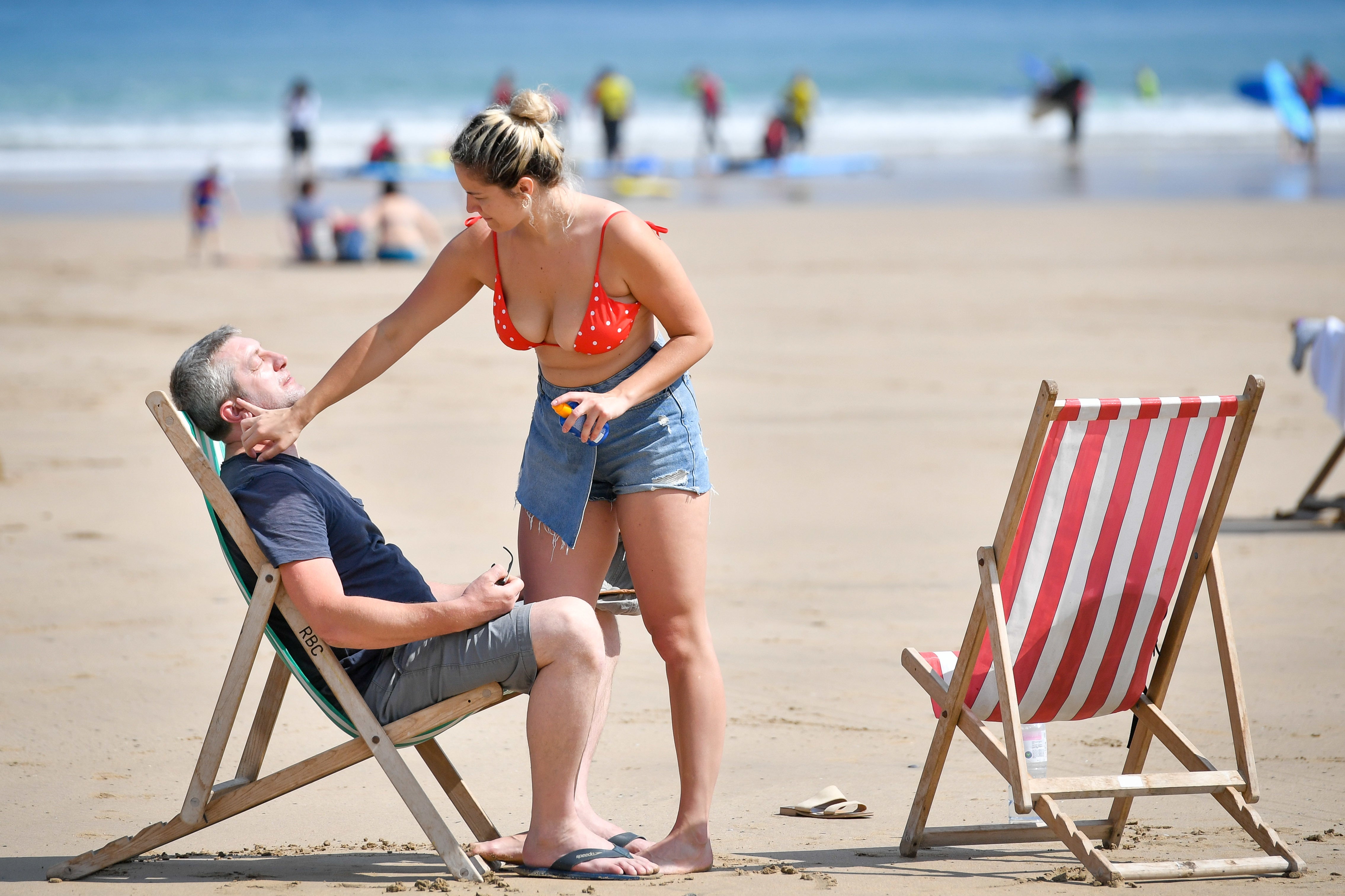 Sunbathers applying sunscreen on Towan beach in Newquay, Cornwall on Thursday