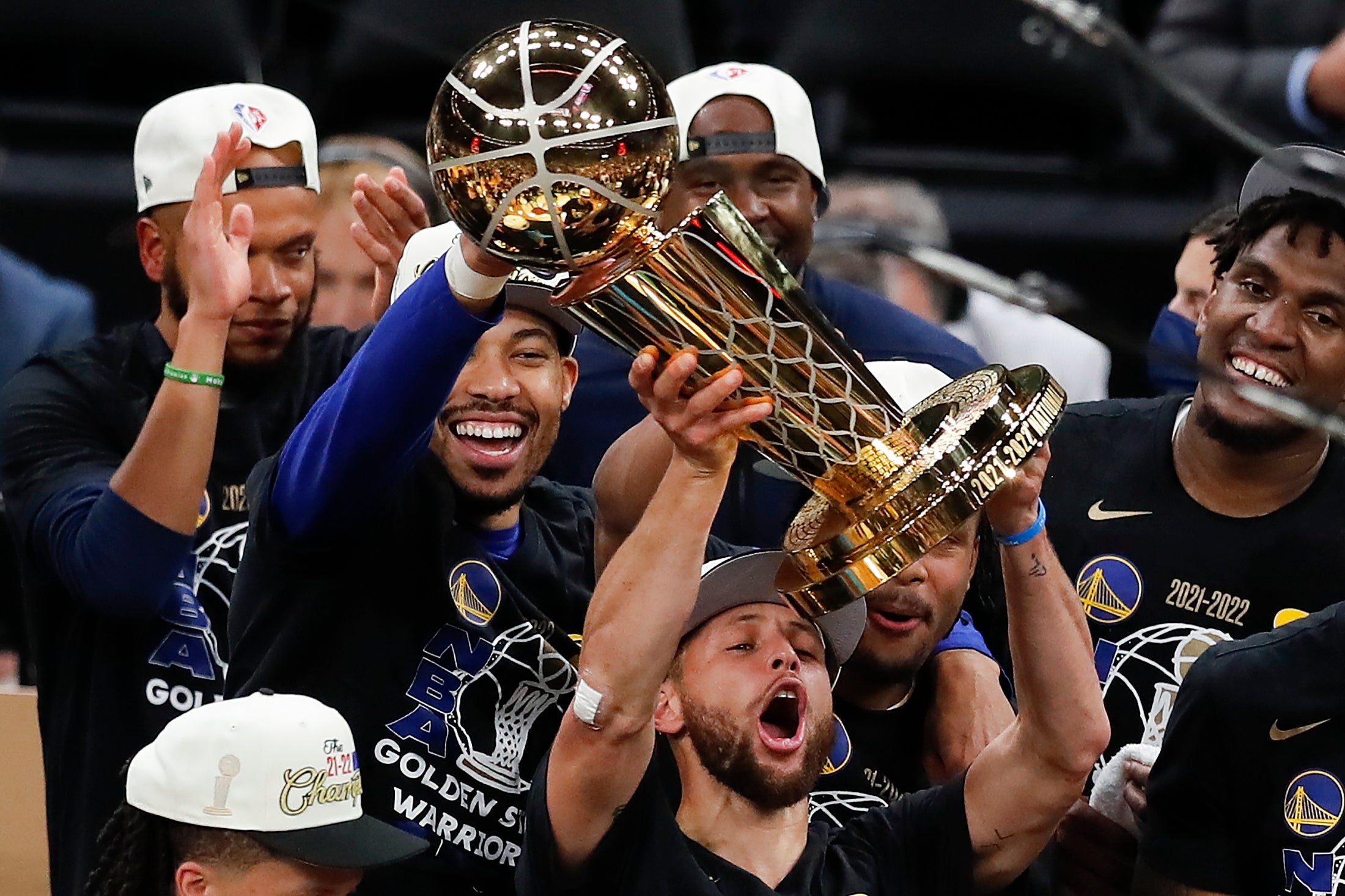 Steph Curry hoists the NBA trophy aloft