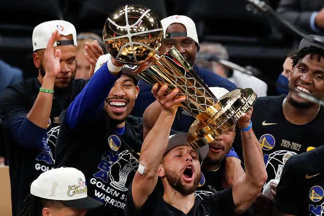 <p>Steph Curry hoists the NBA trophy aloft </p>