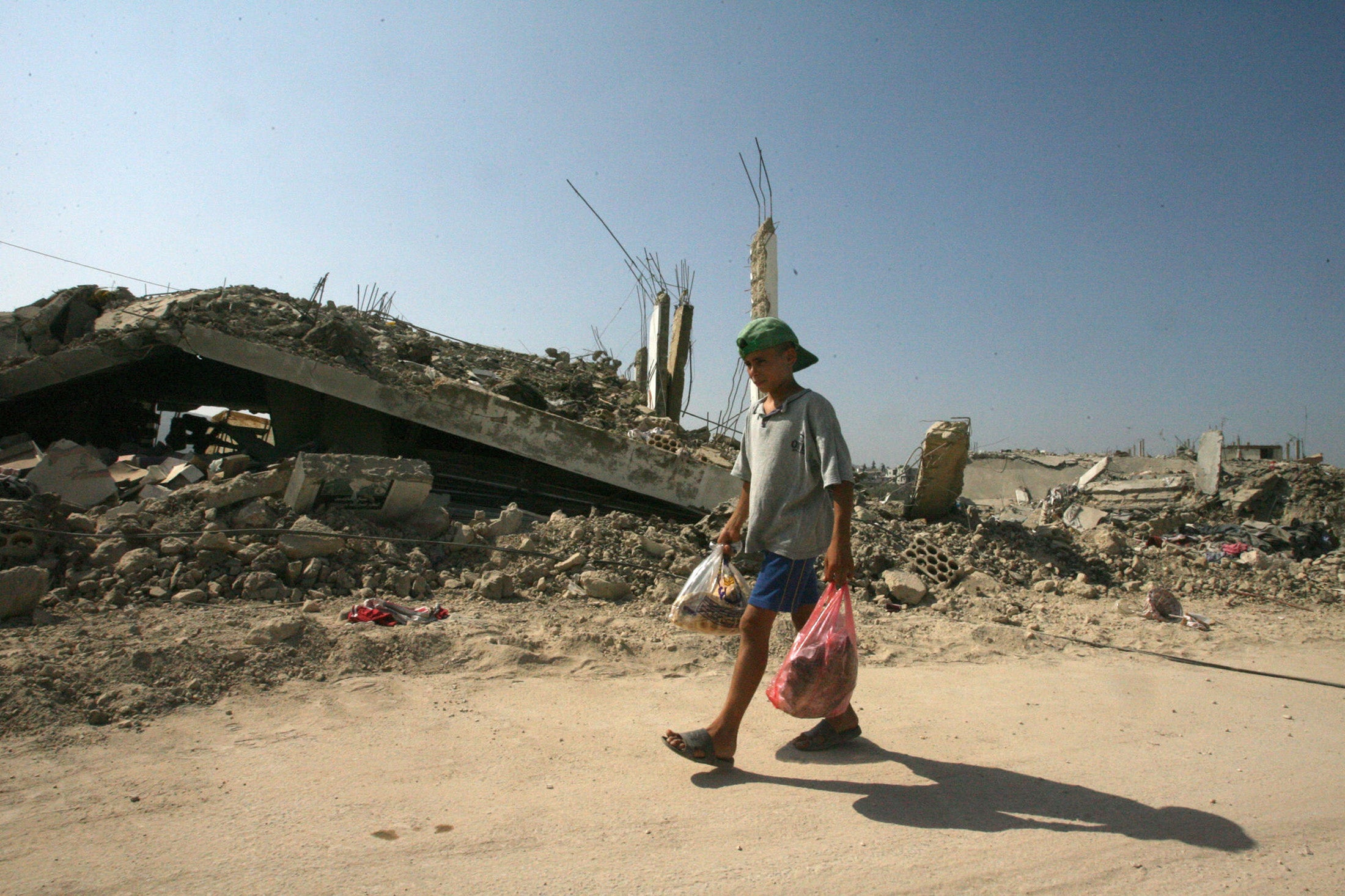 A Lebanese boy passes the rubble of destroyed houses in Srifa, Lebanon, in August 2006