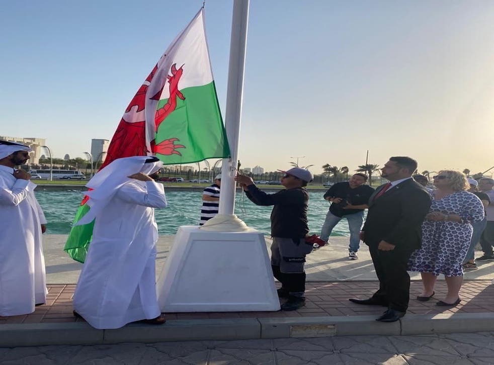 Daniel Phillips enjoys the raising of the Welsh flag at the ceremony in Doha (FCDO/PA)