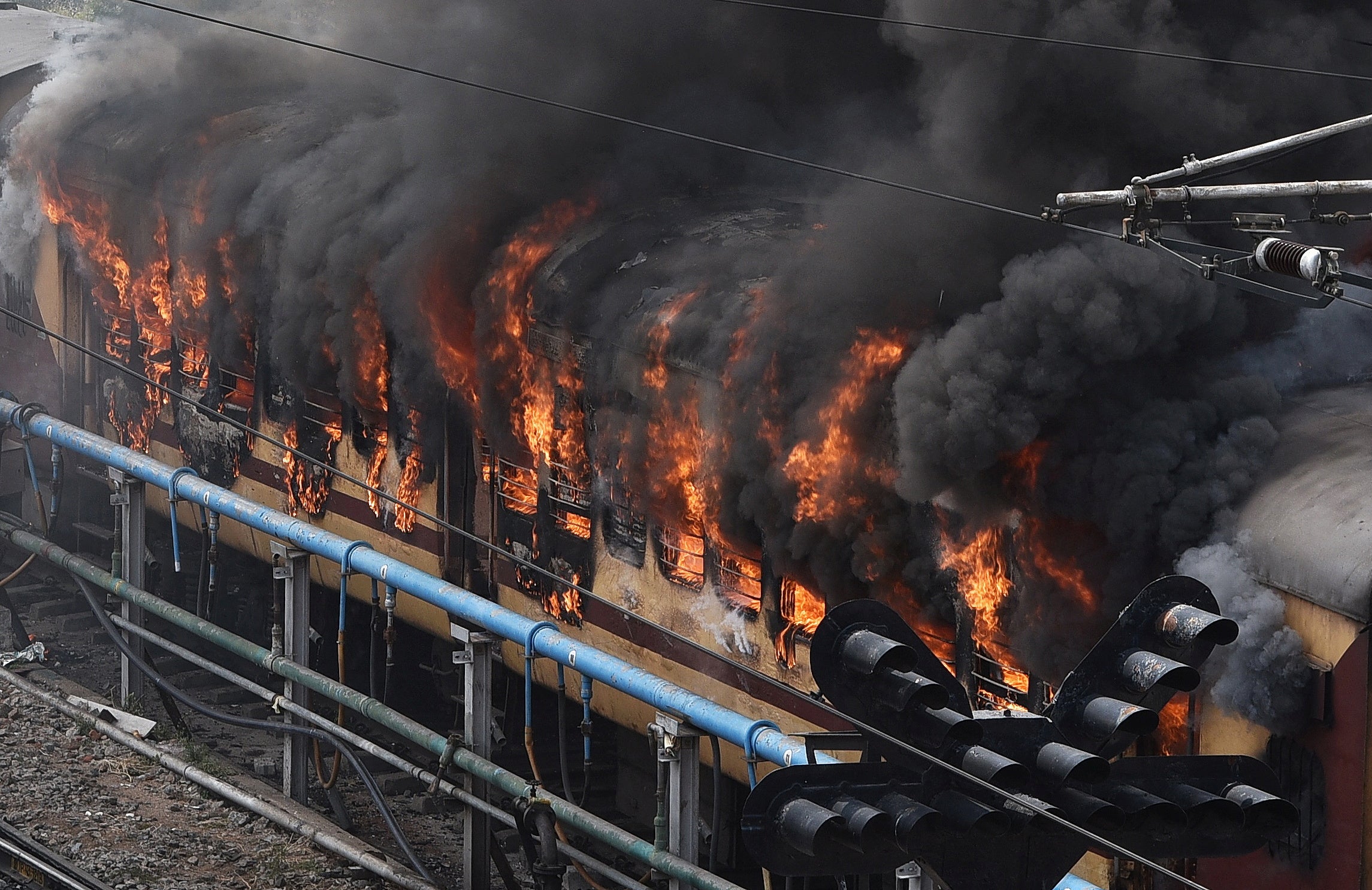 Smoke billows out from a passenger train coach after it was set on fire by protestors during a protest against the ‘Agnipath’ reforms for recruiting personnel for armed forces in Secunderabad city on 17 June