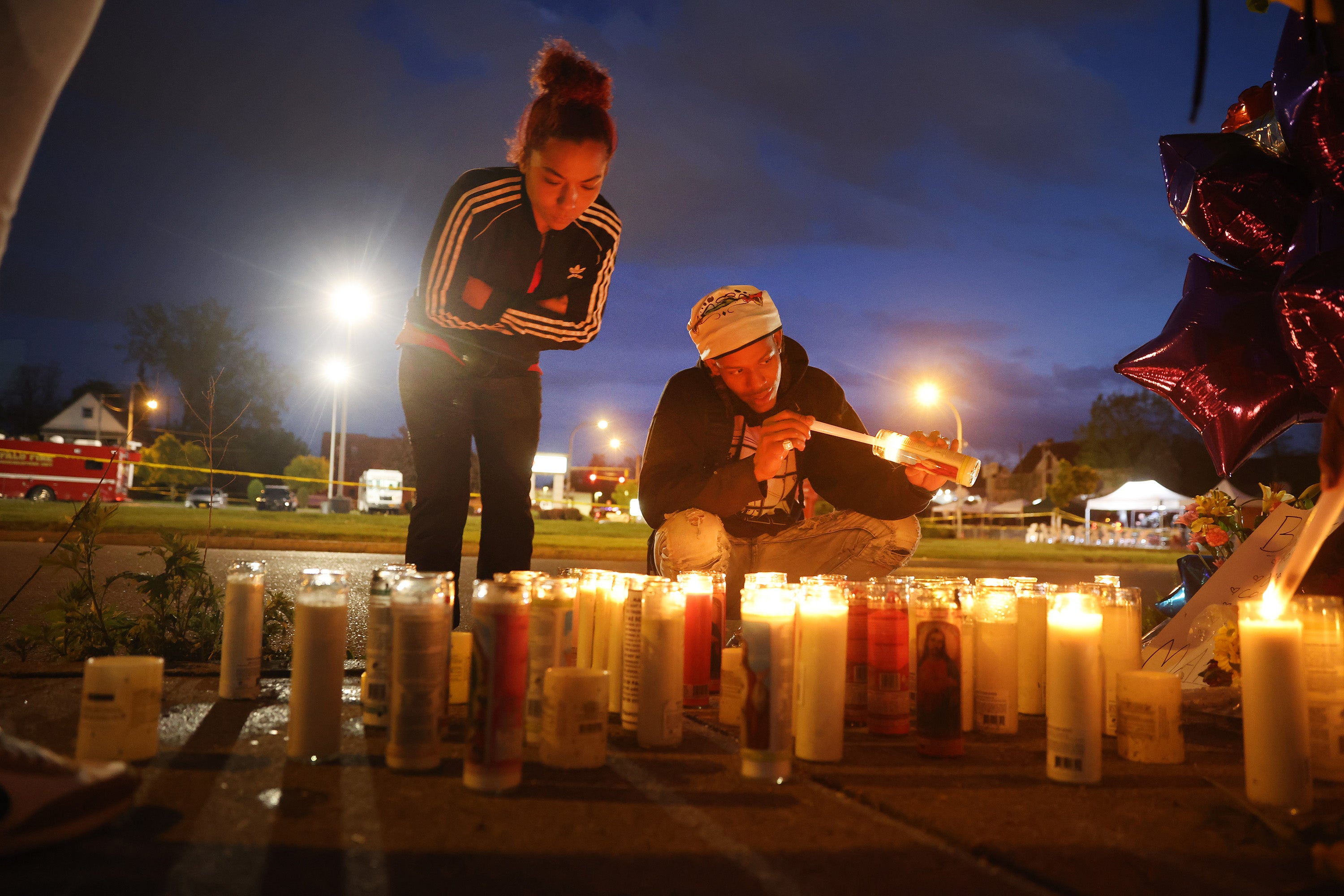 Mourners light candles at a makeshift memorial outside of Tops market in Buffalo where 10 Black people were shot dead