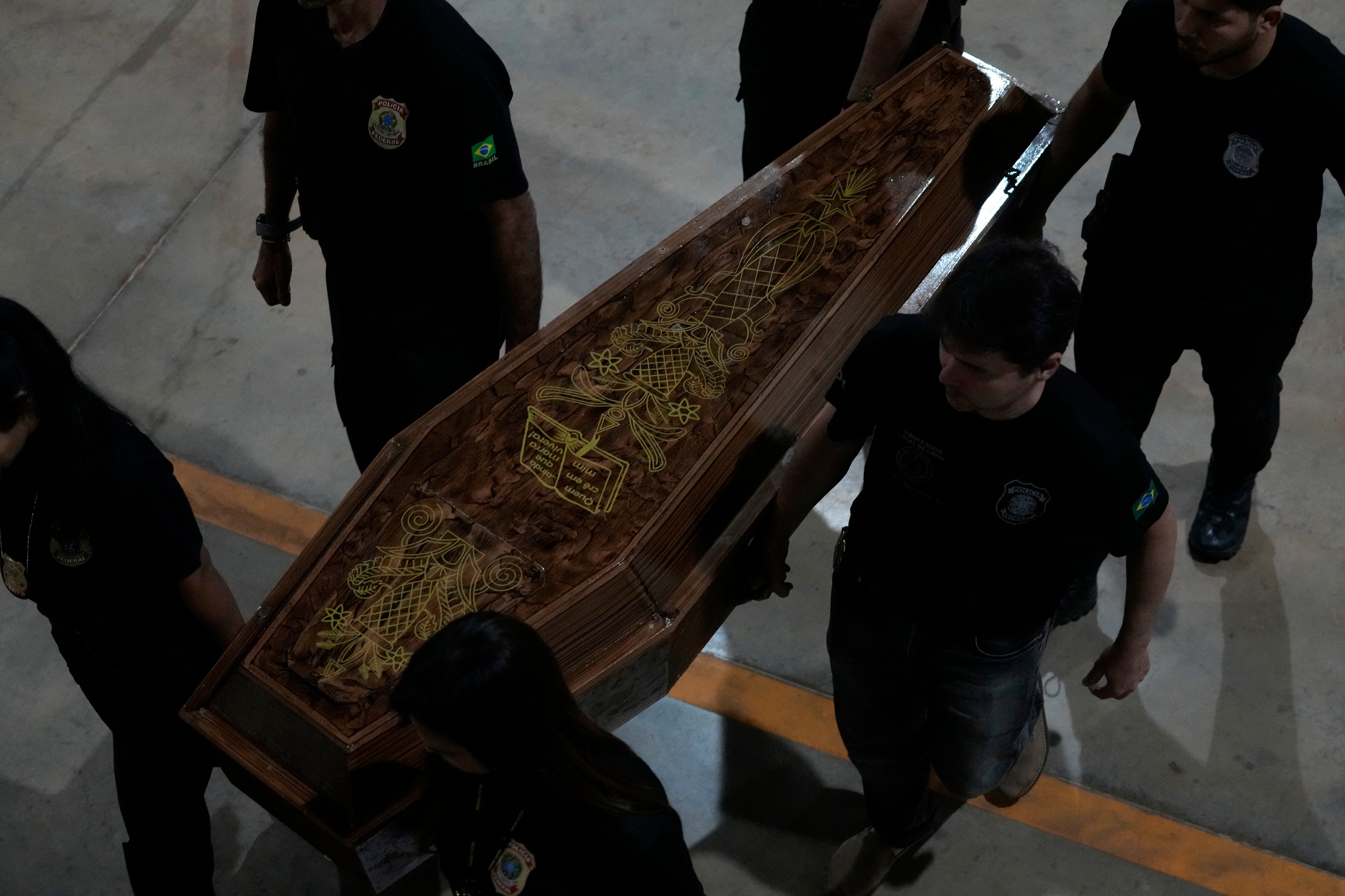 Federal police officers carry remains believed to be of Dom Phillips and Bruno Pereira