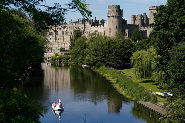 People using a pedal boat make their way along the river Avon by Warwick Castle (Jacob King/PA)