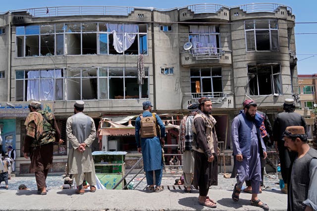 <p>Taliban fighters stand guard in front of the Sikh temple that came under attack in Kabul on 18 June</p>