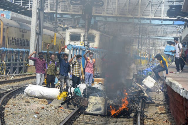 <p>Protesters shout slogans after setting goods and vehicles on fire during a demonstration against the government’s new ‘Agnipath’ recruitment scheme in Secunderabad on 17 June</p>
