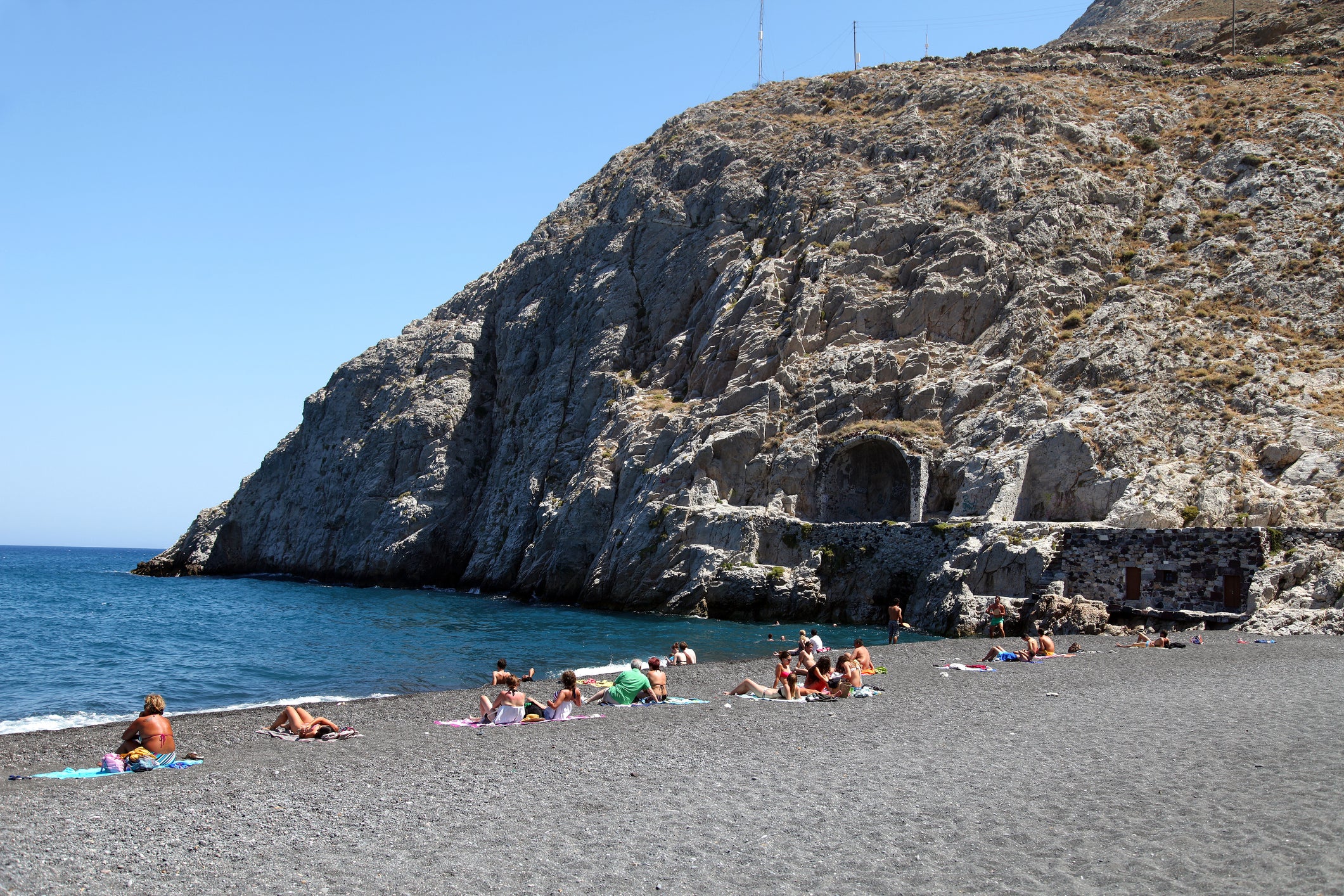 Parents saw the man on Kamari beach, Santorini, photographing the youngsters who were wearing swimsuits