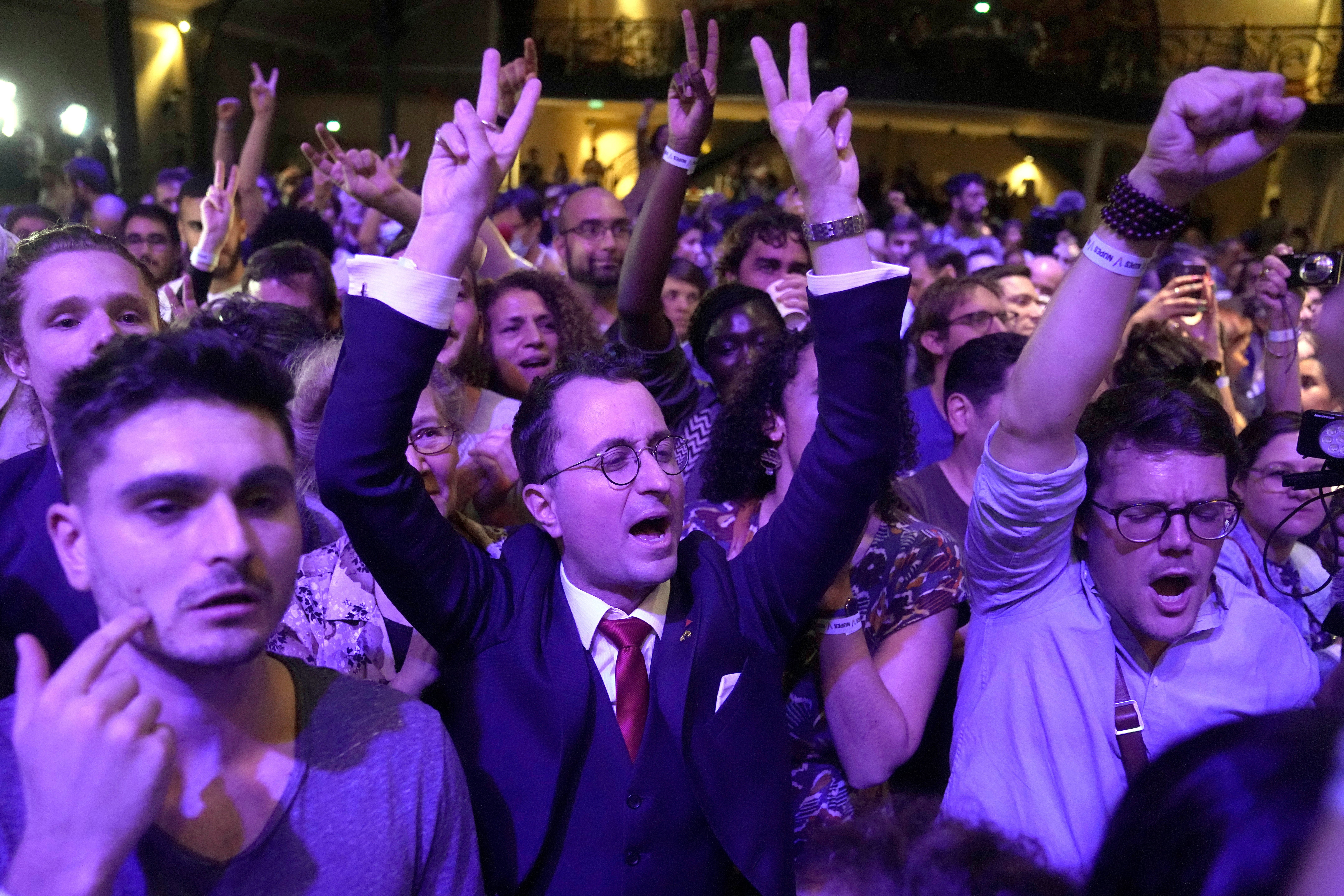 Supporters of hard-left leader Jean-Luc Melenchon react inside his election night headquarters