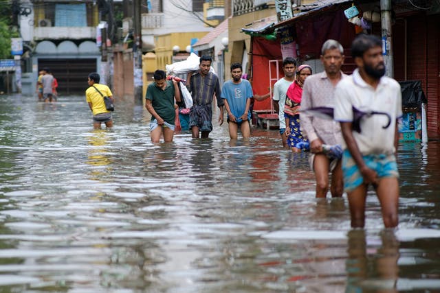 <p>People wade through flood waters in Sylhet, Bangladesh</p>