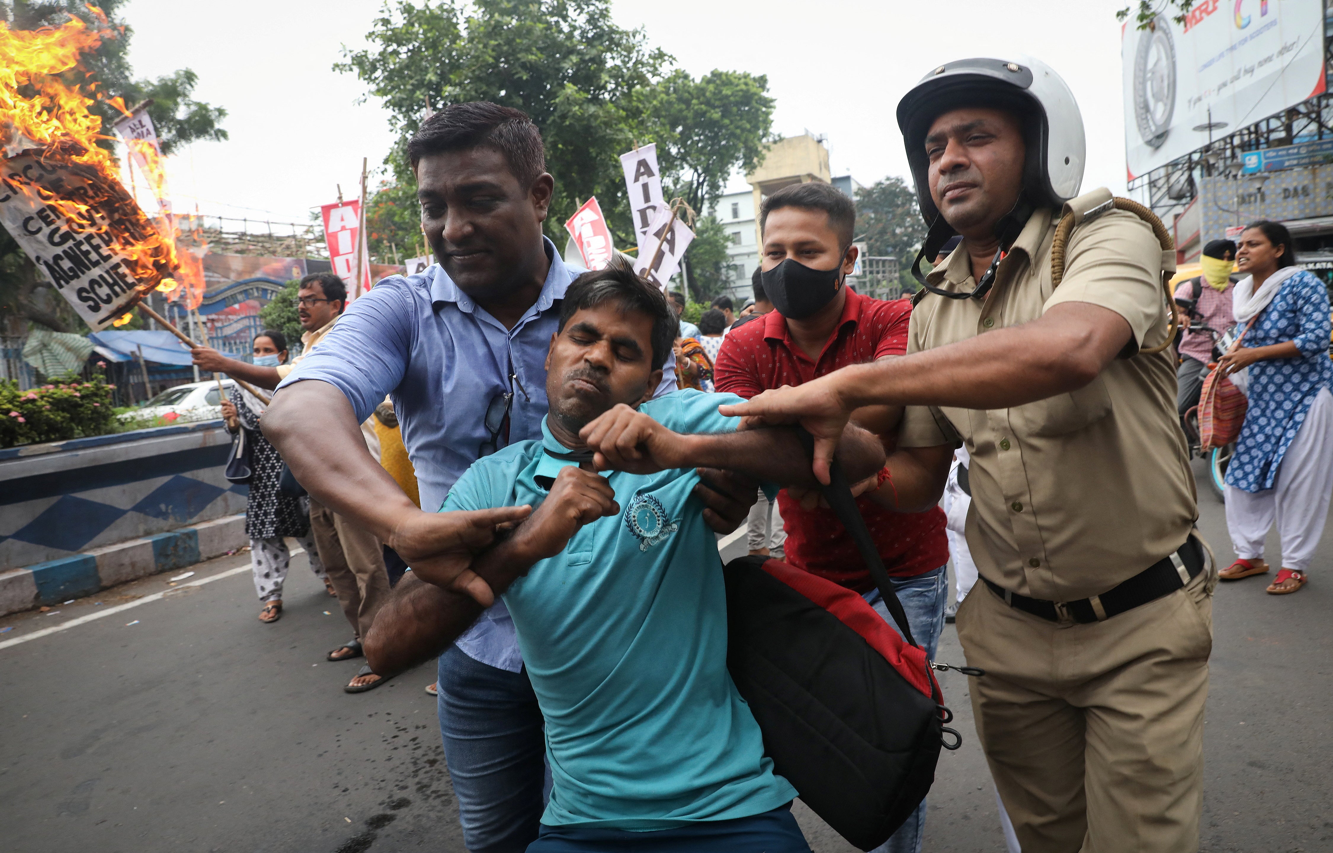 Police detain a demonstrator during a protest against the “Agnipath” scheme