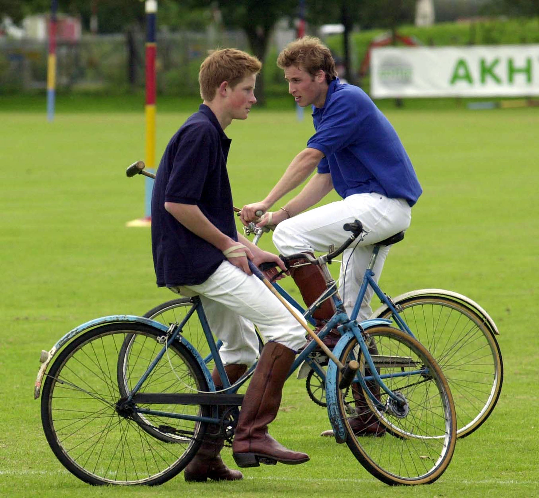 Prince Harry and Prince William take a break whilst playing in the bicycle part of the Jockeys v Eventers Charity polo match in 2002 (Barry Batchelor/PA)