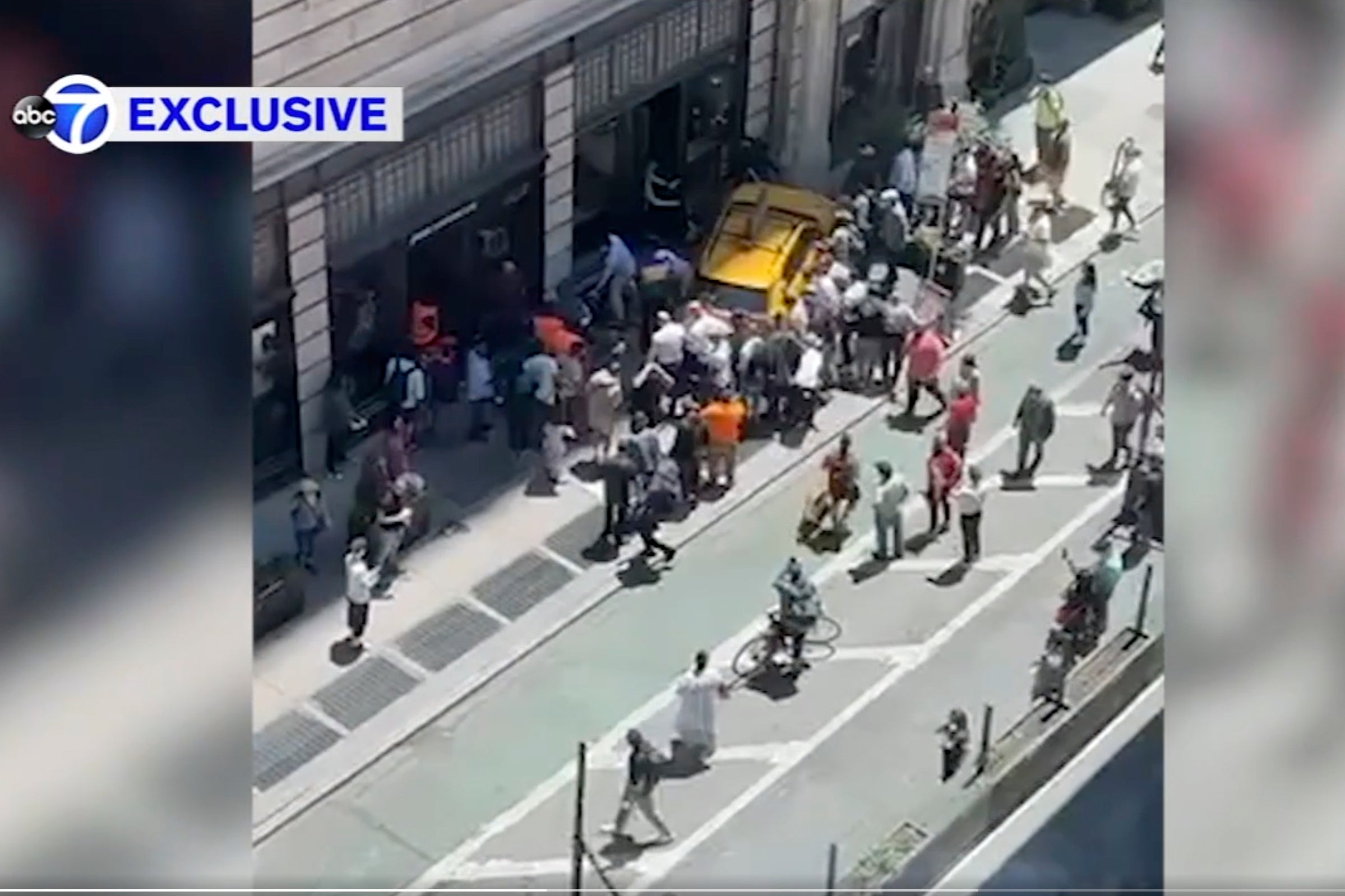 Bystanders move in to assist pedestrians who were struck by a cab that jumped a curb on Broadway