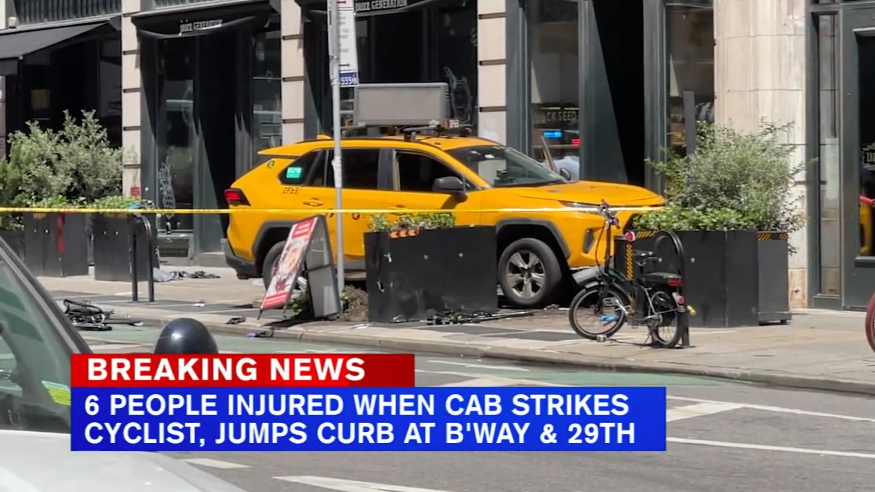 A taxi cab sits on the sidewalk in the Flatiron district after it jumped the curb and struck pedestrians