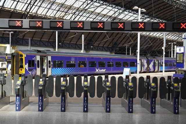 Signs at Glasgow Queen Street station alert travellers to the strike action (PA)