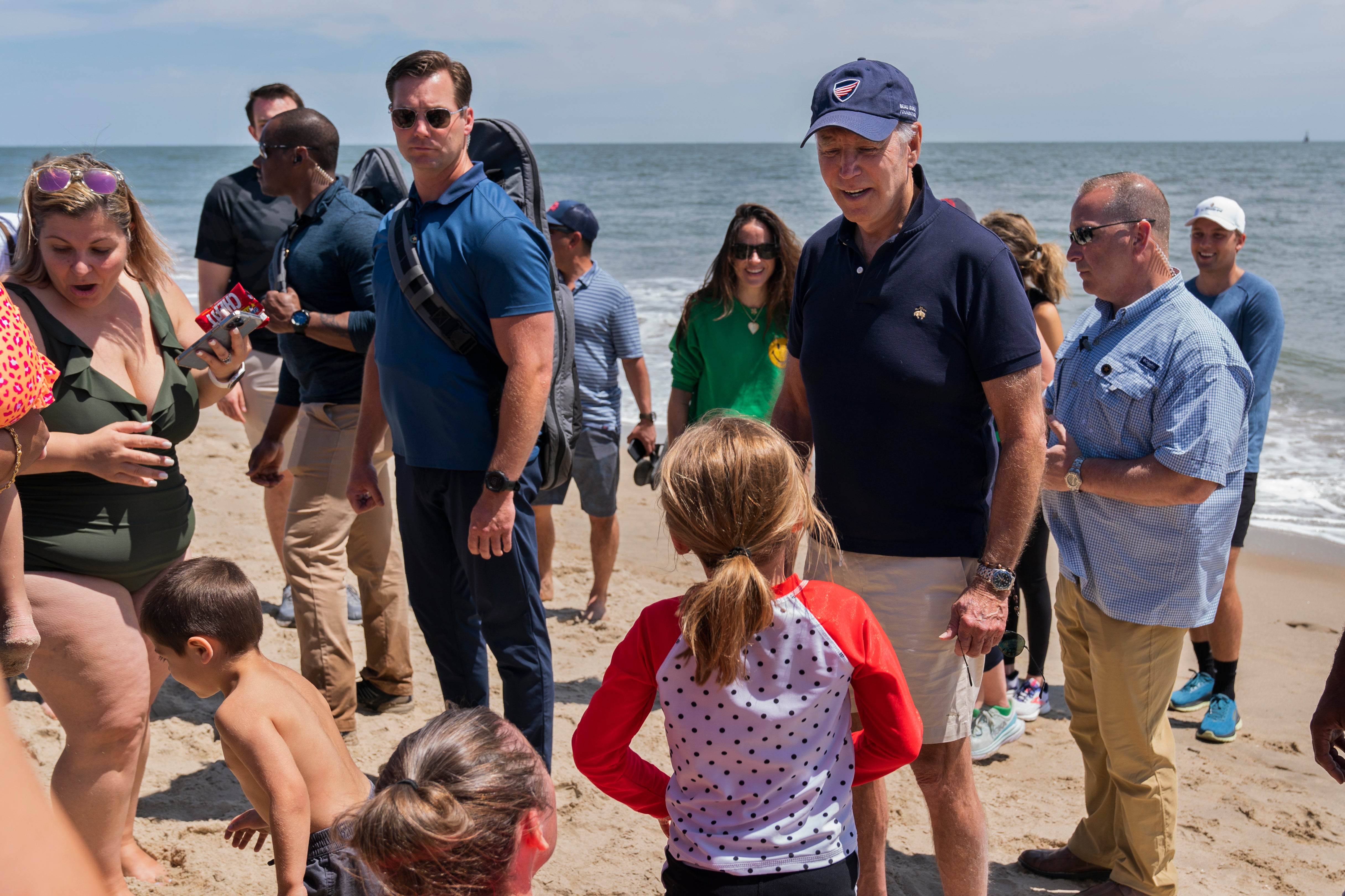 President Joe Biden talks to people as he walks on the beach with his granddaughter Natalie Biden and his daughter Ashley Biden on 20 June 2022