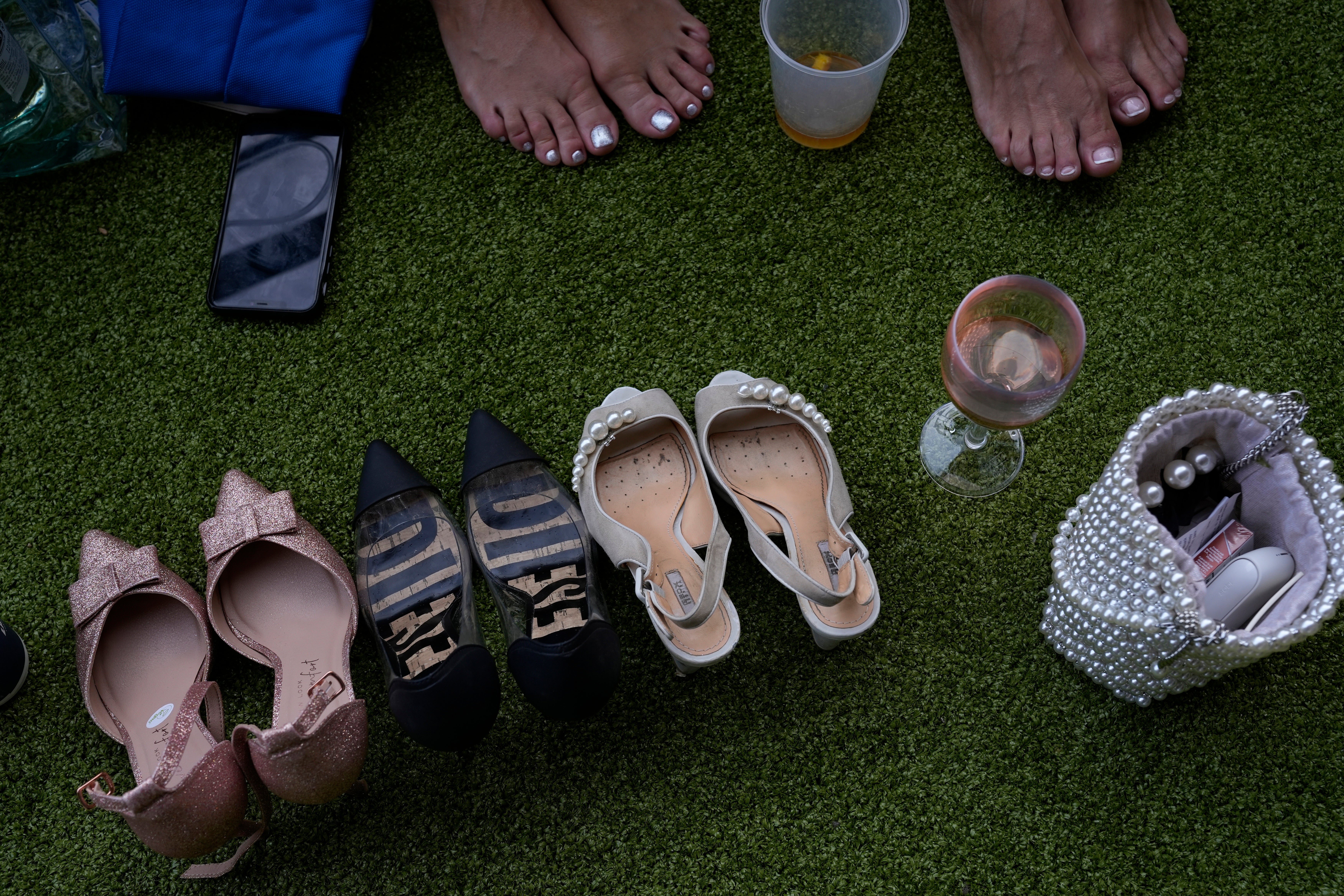 No cheap flats here: racegoers take off their shoes to rest their feet on the third day of the Royal Ascot horserace meeting in June