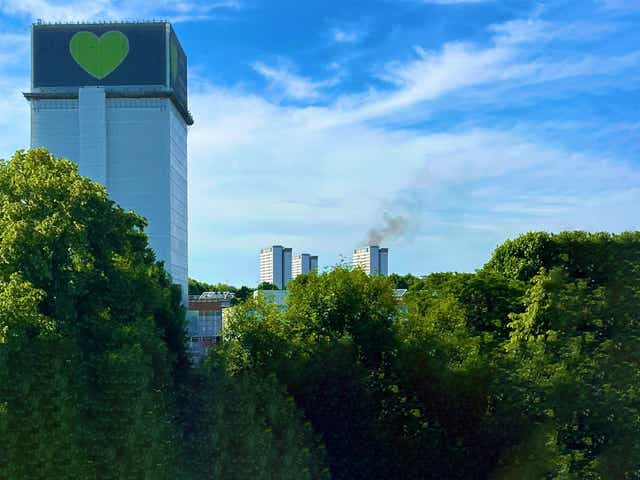 <p>A fire in a flat in Shepherds Bush can be seen behind the site of the Grenfell Tower tragedy </p>