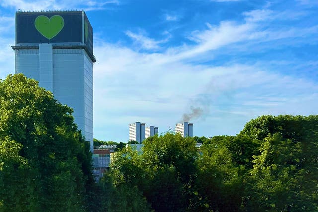 <p>A fire in a flat in Shepherds Bush can be seen behind the site of the Grenfell Tower tragedy </p>